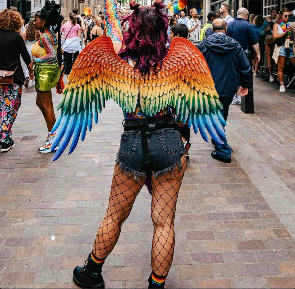 Frau mit regenbogenfarbenen Engelsflügeln auf dem Christopher Street Day