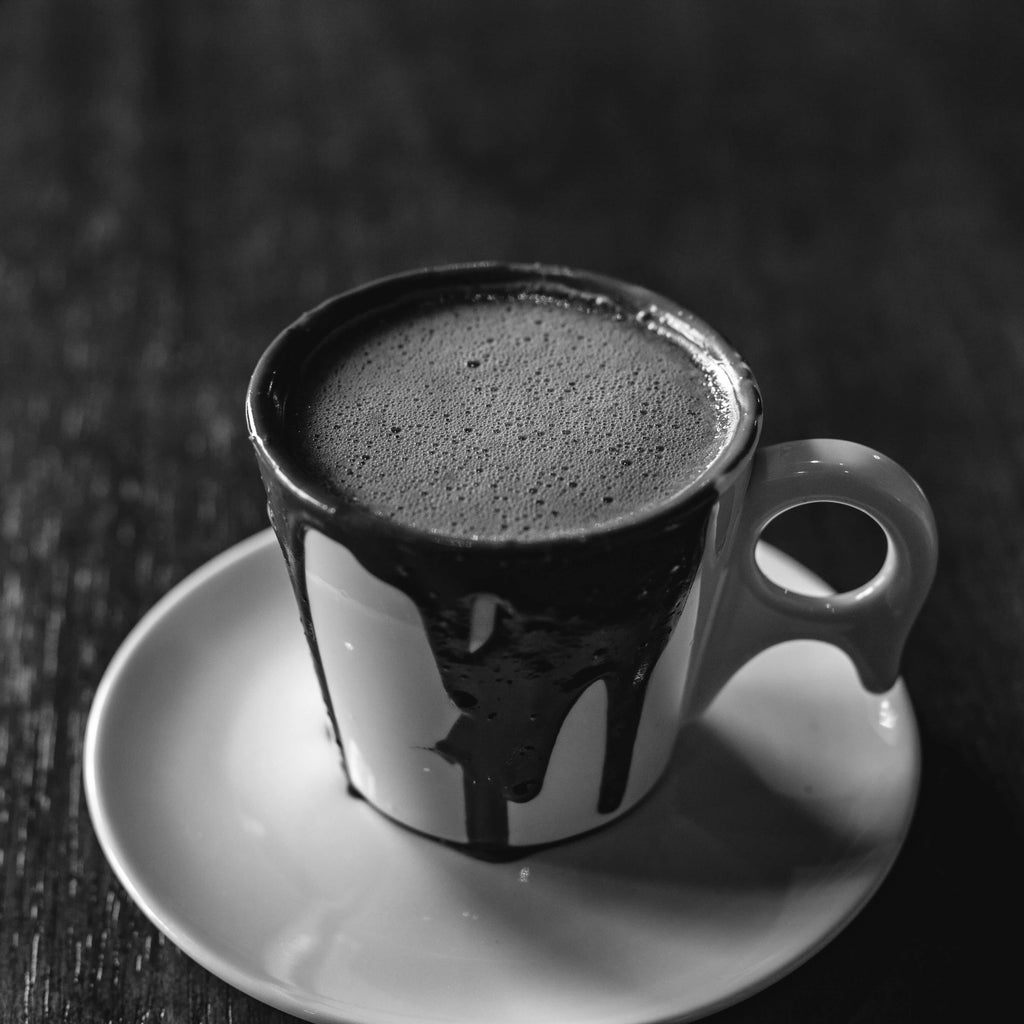 Weisse Tasse mit heisser Schokolade, die überläuft